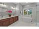 Modern bathroom featuring a soaking tub, marble accents, dual sinks, and glass enclosed shower at 11909 Cupworth Ct, Huntersville, NC 28078