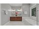 Stylish bathroom featuring marble tiling, a soaking tub, dual sinks, and updated fixtures at 11909 Cupworth Ct, Huntersville, NC 28078