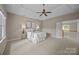 A large bedroom with a tray ceiling, neutral carpeting, a ceiling fan, and a large window at 11909 Cupworth Ct, Huntersville, NC 28078