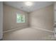 Empty bedroom with neutral walls and carpet, a window, and a door at 11909 Cupworth Ct, Huntersville, NC 28078