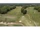 Scenic aerial view of a manicured golf course with sand traps and winding cart paths, surrounded by lush trees at 11909 Cupworth Ct, Huntersville, NC 28078