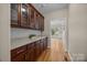 Hallway featuring hardwood floors, glass-door cabinets, and natural light, creating a seamless transition between rooms at 11909 Cupworth Ct, Huntersville, NC 28078