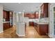 Spacious kitchen featuring dark wood cabinets, stainless steel appliances, and an island with granite countertops at 11909 Cupworth Ct, Huntersville, NC 28078