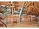 Unfinished attic with visible beams, insulation, a window, and storage options at 12900 Westmoreland Rd, Huntersville, NC 28078