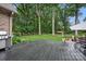 Lush backyard featuring a deck, fire pit, shed, and mature trees at 12900 Westmoreland Rd, Huntersville, NC 28078