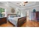 Bedroom featuring a wooden bed with blue pillows, two windows and a patterned ceiling at 12900 Westmoreland Rd, Huntersville, NC 28078