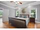 Bedroom with a wooden bed and two windows with views and ceiling fan at 12900 Westmoreland Rd, Huntersville, NC 28078