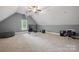 Spacious bonus room with vaulted ceilings, fan, carpeted floor, and a cityscape photograph at 12900 Westmoreland Rd, Huntersville, NC 28078
