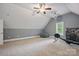 Large carpeted bonus room with a ceiling fan, exercise equipment, and natural light at 12900 Westmoreland Rd, Huntersville, NC 28078