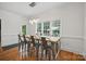 A dining room with a large table, views of the backyard, and modern lighting at 12900 Westmoreland Rd, Huntersville, NC 28078