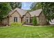 Charming brick home featuring a lush lawn, mature trees, and tasteful landscaping at 12900 Westmoreland Rd, Huntersville, NC 28078