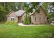 Charming brick home with lush green lawn and mature landscaping, creating an inviting curb appeal at 12900 Westmoreland Rd, Huntersville, NC 28078