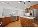 Modern kitchen with stainless steel appliances and wooden cabinets, and island at 12900 Westmoreland Rd, Huntersville, NC 28078