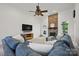 The living room boasts a stone fireplace, a ceiling fan, and a comfortable blue sectional sofa at 12900 Westmoreland Rd, Huntersville, NC 28078
