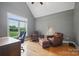 Bright home office featuring a window with views and leather chairs with a wood desk at 12900 Westmoreland Rd, Huntersville, NC 28078