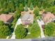 Overhead shot of a beautiful home surrounded by mature trees, a long driveway, and meticulously maintained lawns at 13056 Long Common Pkwy, Huntersville, NC 28078