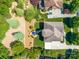 Aerial view of a home featuring an outdoor patio, driveway, manicured lawn, mature trees and surrounding greenery at 13056 Long Common Pkwy, Huntersville, NC 28078