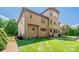 Brick home exterior featuring a well-maintained lawn, a small fence, and an expansive backyard at 13056 Long Common Pkwy, Huntersville, NC 28078