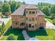Aerial shot of a brick home with a backyard, a paver patio, and well-manicured lawn surrounded by trees at 13056 Long Common Pkwy, Huntersville, NC 28078