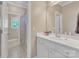 Bright bathroom featuring white cabinets, double sinks, large mirrors and a shower and bath at 13056 Long Common Pkwy, Huntersville, NC 28078