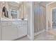 Bathroom featuring neutral paint, white cabinets, double sinks, large mirrors and a bath at 13056 Long Common Pkwy, Huntersville, NC 28078
