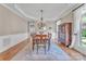 Formal dining room featuring hardwood floors, wainscoting, elegant lighting, and a large cabinet at 13056 Long Common Pkwy, Huntersville, NC 28078