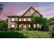 Elegant stone home with manicured lawn, covered porch and symmetrical window design at 13056 Long Common Pkwy, Huntersville, NC 28078