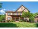 Stunning brick and stone home featuring a manicured lawn, mature landscaping and inviting covered front porch at 13056 Long Common Pkwy, Huntersville, NC 28078