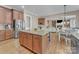 Open kitchen with a granite island, stainless steel appliances, and view into the living room at 13056 Long Common Pkwy, Huntersville, NC 28078