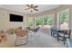 Carpeted living room with a ceiling fan, a flat screen television, and large windows overlooking trees at 13056 Long Common Pkwy, Huntersville, NC 28078