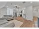 Inviting open-concept living space with a gray sofa, kitchen, and hardwood flooring at 13056 Long Common Pkwy, Huntersville, NC 28078