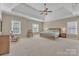 Spacious main bedroom with neutral paint, tray ceilings, carpeted floors and large windows overlooking trees at 13056 Long Common Pkwy, Huntersville, NC 28078