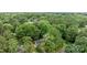Aerial view showcases a home nestled within a dense forest, emphasizing its secluded location at 13446 Idlefield Ln, Matthews, NC 28105