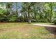 Large backyard featuring a spacious lawn, mature trees, and a storage shed providing ample outdoor space at 13446 Idlefield Ln, Matthews, NC 28105