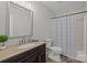 Bathroom featuring granite countertop vanity, decorative plant, and shower with patterned curtain at 13446 Idlefield Ln, Matthews, NC 28105