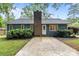 Well-maintained home exterior with lush landscaping and a brick chimney on a sunny day at 13446 Idlefield Ln, Matthews, NC 28105