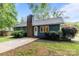 Charming single-story home featuring a classic brick chimney and lush landscaping enhancing curb appeal at 13446 Idlefield Ln, Matthews, NC 28105