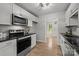 Well-lit kitchen with stainless steel appliances, sleek countertops, and light wood floors at 13446 Idlefield Ln, Matthews, NC 28105