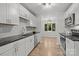 Bright kitchen featuring modern appliances, white cabinetry, and hardwood floors at 13446 Idlefield Ln, Matthews, NC 28105