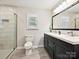 A bathroom with a double vanity, large mirror, and a glass door shower at 136 Gable Rd, Mooresville, NC 28115