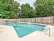 A pristine in-ground pool with a step-in spa, surrounded by lush greenery for ultimate relaxation and recreation at 136 Gable Rd, Mooresville, NC 28115