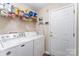 Functional laundry room with a washer, dryer, shelving, and easy access to the outside at 13830 Riding Hill Ave, Charlotte, NC 28213