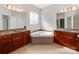 The main bathroom features 2 vanities, tile floors and a corner soaking tub at 15001 Rosemary Way Dr, Huntersville, NC 28078