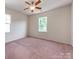 Light-filled bedroom with carpet, natural light from the windows, and a modern ceiling fan at 15001 Rosemary Way Dr, Huntersville, NC 28078