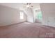 Spacious bedroom featuring neutral walls, a ceiling fan and large windows at 15001 Rosemary Way Dr, Huntersville, NC 28078