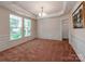 Formal dining room featuring wainscoting, neutral carpet, modern chandelier, and large bright windows at 15001 Rosemary Way Dr, Huntersville, NC 28078