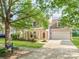 Inviting home featuring manicured lawn, mature trees, and an attached two car garage at 15001 Rosemary Way Dr, Huntersville, NC 28078