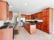 Modern kitchen features wood cabinets, granite countertops, tile floors, and stainless steel appliances at 15001 Rosemary Way Dr, Huntersville, NC 28078