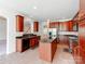 This kitchen boasts cherry cabinets, stainless steel appliances, a central island, and beautiful countertops at 15001 Rosemary Way Dr, Huntersville, NC 28078