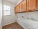 Functional laundry room showcasing cabinetry, utility sink and window at 15001 Rosemary Way Dr, Huntersville, NC 28078